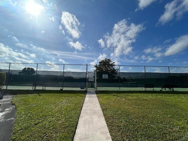 view of sport court featuring a yard and fence