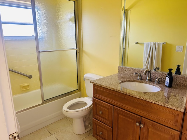 bathroom with tile patterned floors, toilet, vanity, and shower / bath combination with glass door