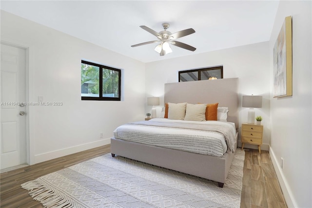 bedroom featuring light wood-type flooring, baseboards, and ceiling fan