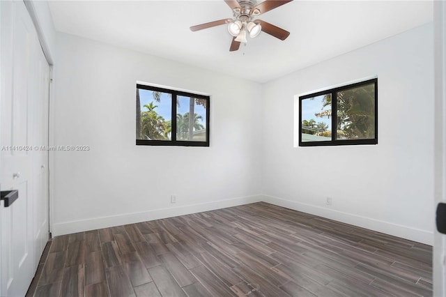 unfurnished room with a wealth of natural light, baseboards, dark wood finished floors, and ceiling fan