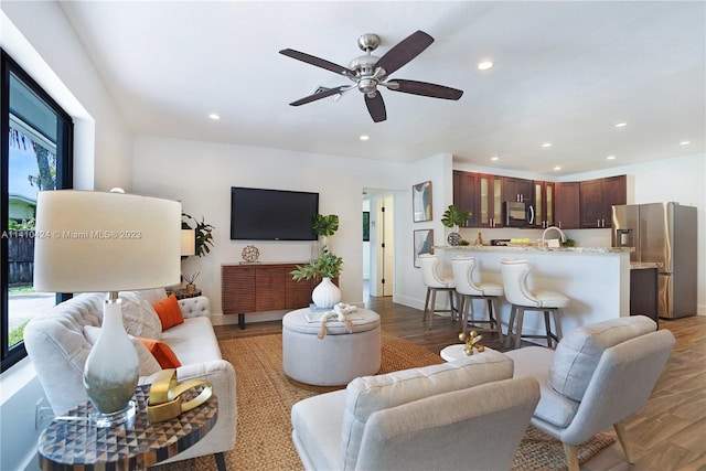 living area with recessed lighting, baseboards, wood finished floors, and ceiling fan