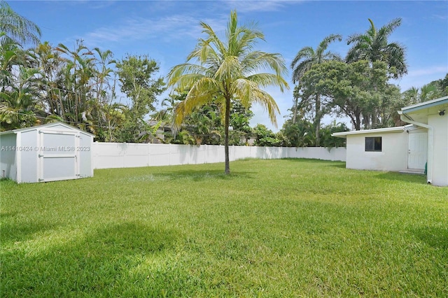 view of yard with an outbuilding, a shed, and fence