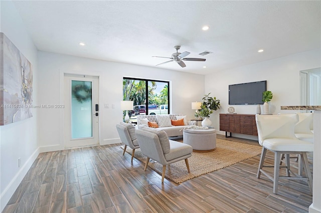 living area featuring visible vents, recessed lighting, baseboards, and wood finished floors