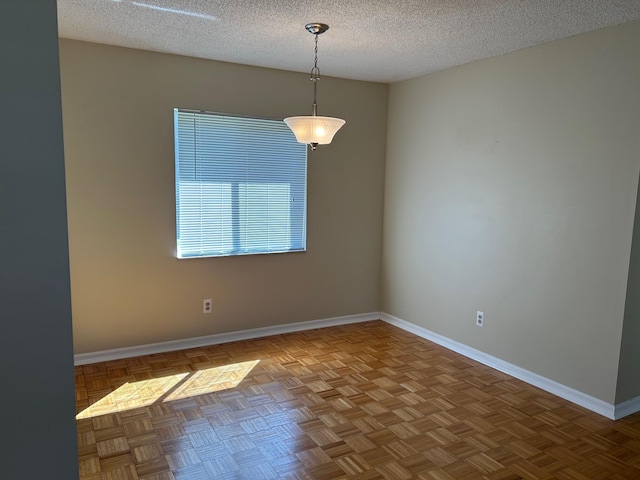 spare room with baseboards and a textured ceiling