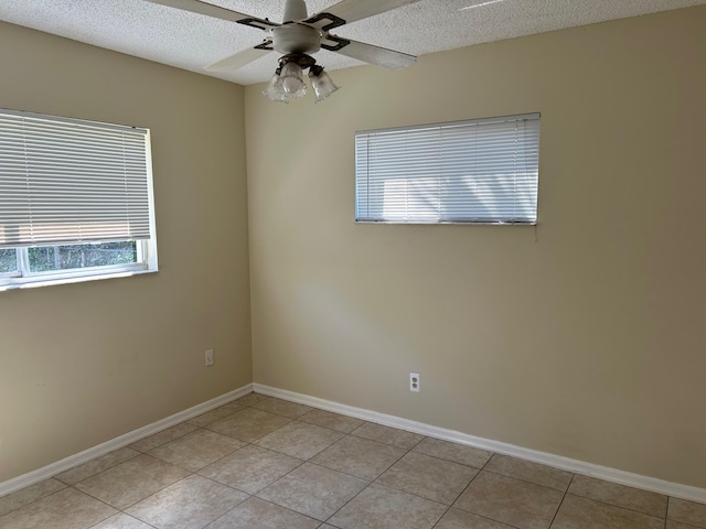 unfurnished room featuring light tile patterned floors, baseboards, a textured ceiling, and ceiling fan