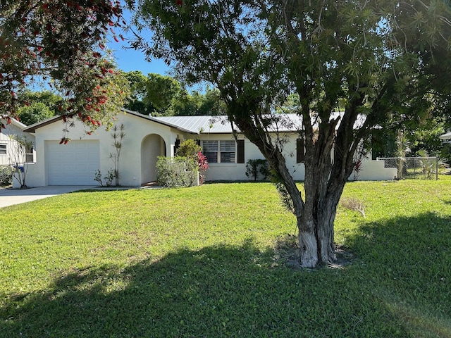 view of front of property with a front lawn, concrete driveway, a garage, and stucco siding