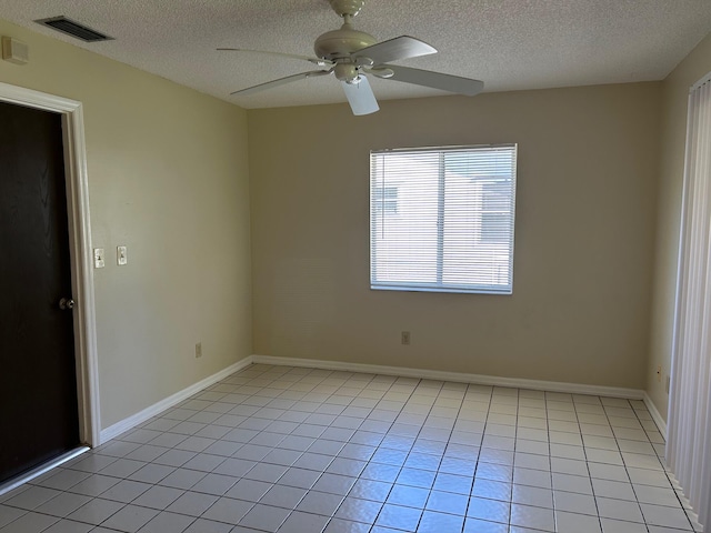 unfurnished room featuring baseboards, visible vents, light tile patterned flooring, ceiling fan, and a textured ceiling