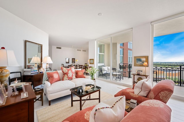 living room with wood finished floors, visible vents, and expansive windows