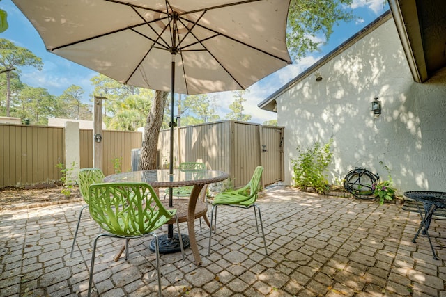 view of patio with outdoor dining area and fence