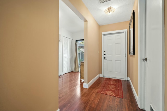 entryway featuring dark wood-style floors, baseboards, and a textured ceiling