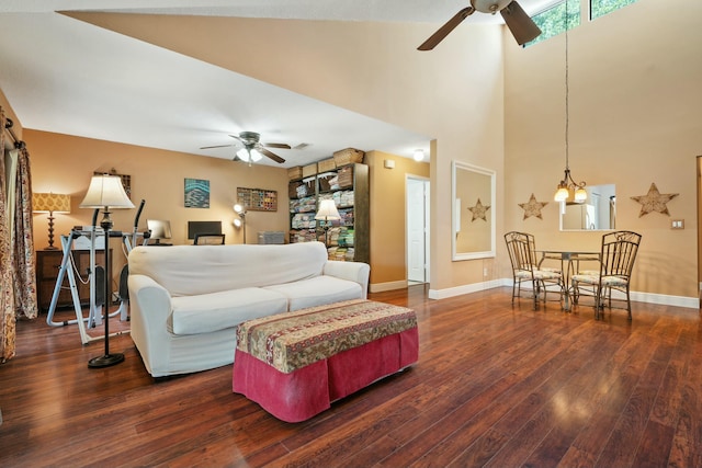 living area featuring ceiling fan with notable chandelier, baseboards, and wood-type flooring