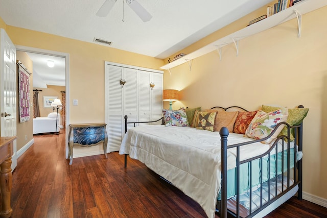 bedroom with visible vents, wood finished floors, a closet, baseboards, and ceiling fan