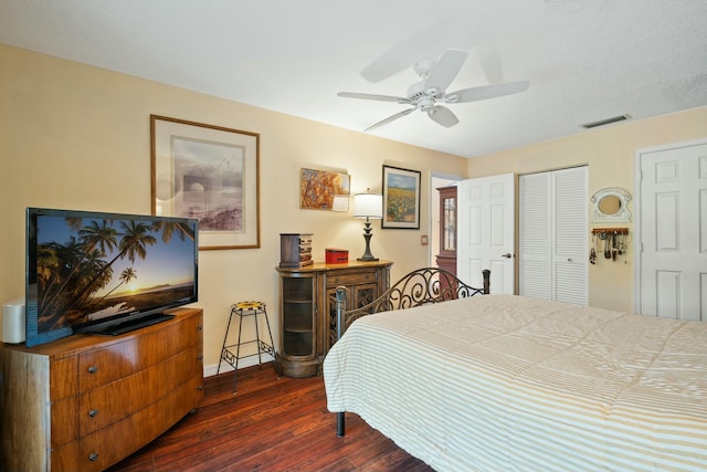 bedroom with visible vents, baseboards, a closet, a ceiling fan, and dark wood-style flooring