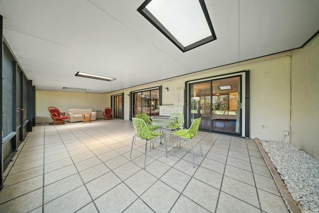 unfurnished sunroom featuring a skylight