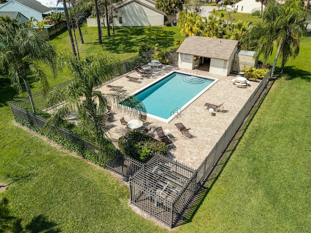 pool featuring fence, a yard, an outdoor structure, a storage structure, and a patio area