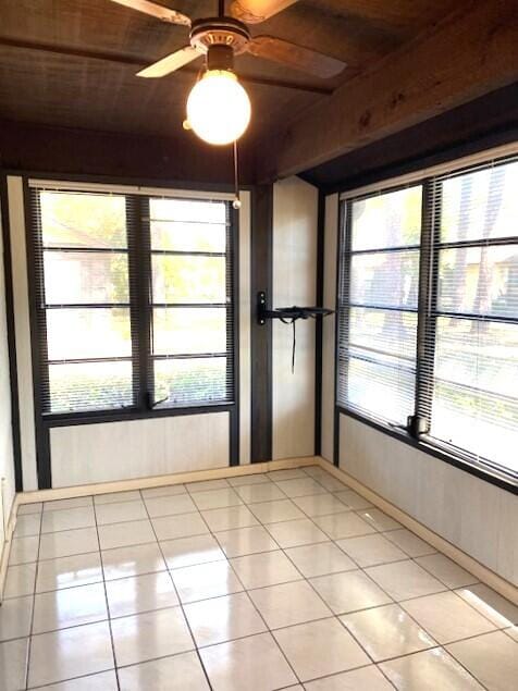 unfurnished sunroom featuring plenty of natural light, ceiling fan, and wooden ceiling