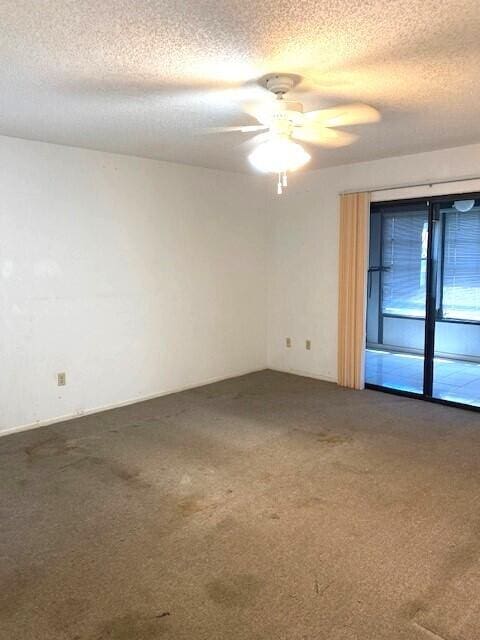 empty room with a textured ceiling, carpet, and ceiling fan