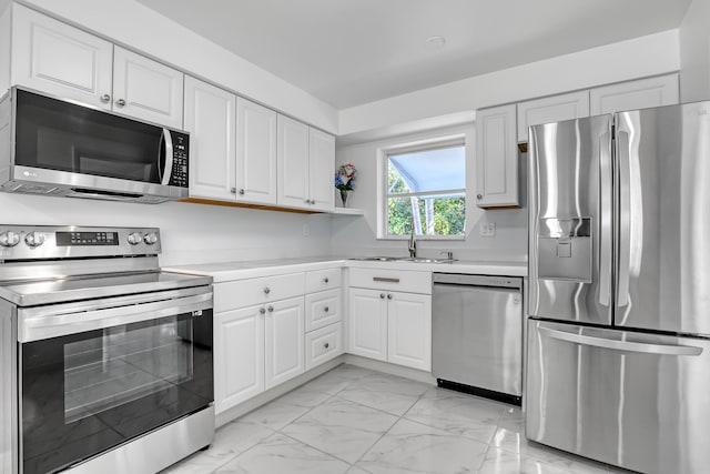 115 Elwa Pl, West Palm Beach, FL 33405 - kitchen with appliances with stainless steel finishes, light marble finish flooring, a sink, light countertops, and white cabinetry