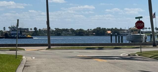 exterior space featuring traffic signs, curbs, and a water view