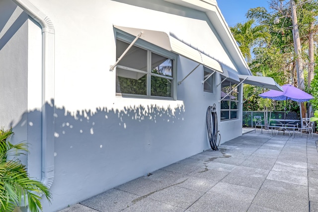 115 Elwa Pl, West Palm Beach, FL 33405 - view of home's exterior with stucco siding, fence, and a patio