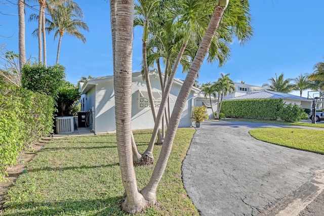 115 Elwa Pl, West Palm Beach, FL 33405 - view of home's exterior featuring driveway, a yard, central AC unit, and stucco siding