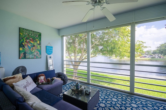 living area featuring a ceiling fan and a water view