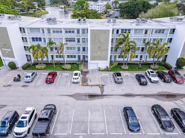 view of building exterior featuring a water view and uncovered parking