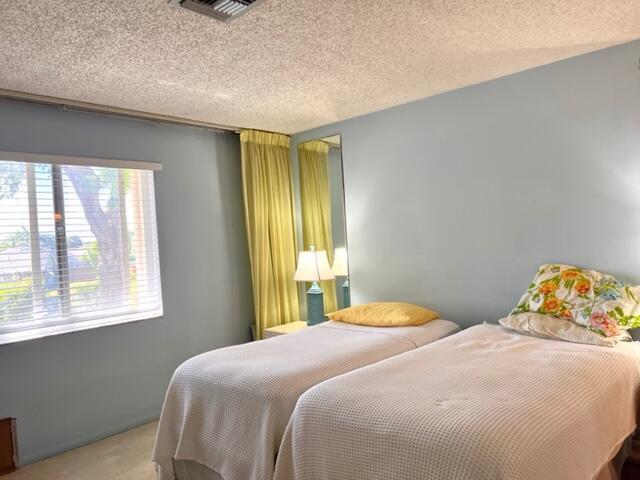 carpeted bedroom with visible vents and a textured ceiling