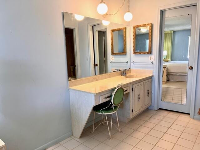 bathroom featuring tile patterned flooring, vanity, and baseboards