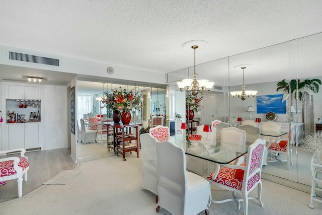 dining room with an inviting chandelier, light colored carpet, visible vents, and a textured ceiling