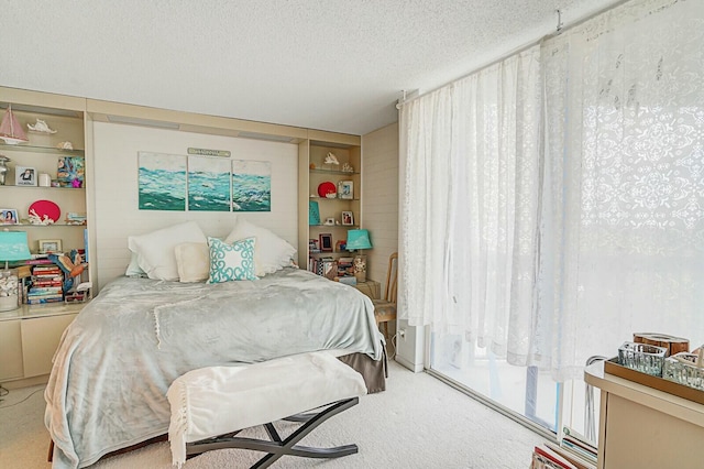 carpeted bedroom featuring a textured ceiling and access to outside