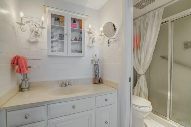 bathroom featuring vanity, toilet, visible vents, and a stall shower