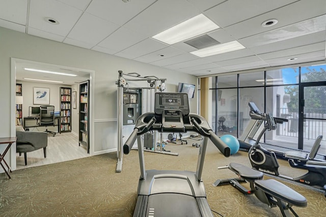 gym with a drop ceiling and floor to ceiling windows