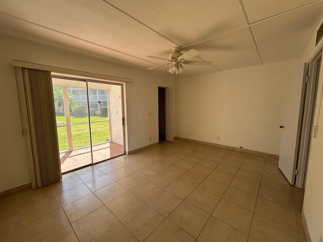 spare room featuring light tile patterned flooring, baseboards, and a ceiling fan