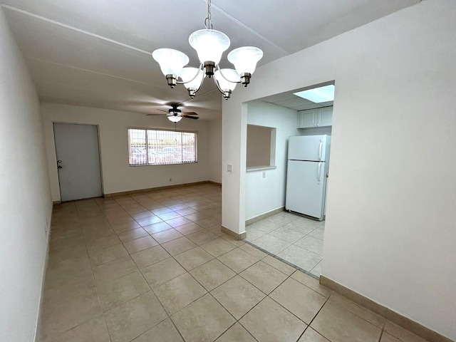 unfurnished room with light tile patterned floors, ceiling fan with notable chandelier, and baseboards