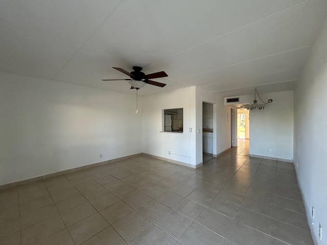 empty room featuring light tile patterned flooring, visible vents, baseboards, and ceiling fan