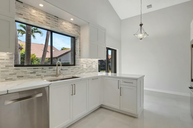 kitchen with a sink, light stone counters, tasteful backsplash, stainless steel dishwasher, and a peninsula