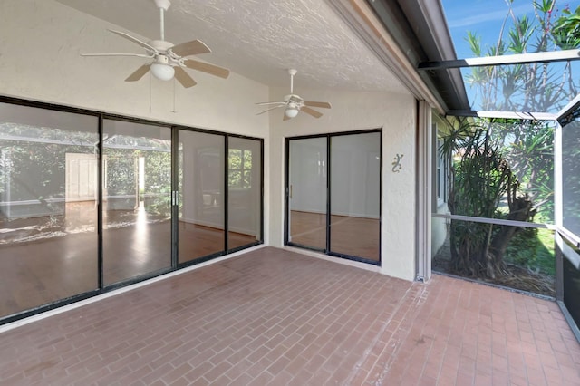 unfurnished sunroom featuring ceiling fan