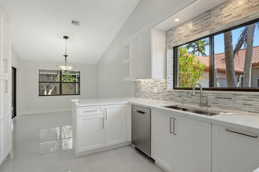 kitchen with tasteful backsplash, a sink, dishwasher, white cabinets, and open shelves