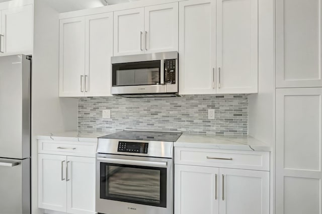 kitchen featuring light stone counters, stainless steel appliances, tasteful backsplash, and white cabinets