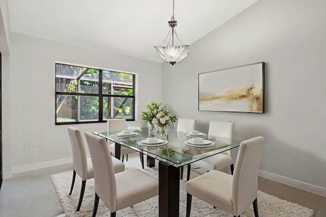 dining area featuring a notable chandelier, baseboards, and wood finished floors