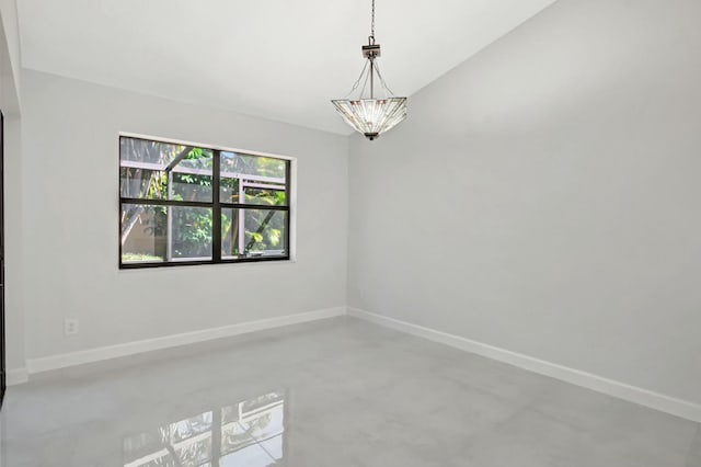 empty room with an inviting chandelier, baseboards, and finished concrete floors