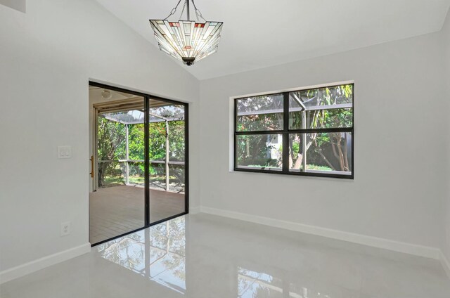 spare room featuring baseboards, plenty of natural light, and a chandelier