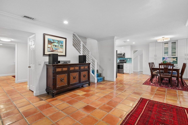 interior space with light tile patterned flooring, visible vents, stairs, and baseboards