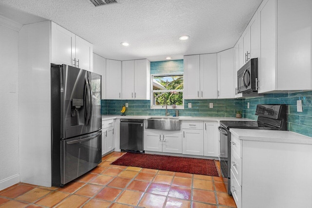 kitchen with a sink, decorative backsplash, black appliances, white cabinets, and light countertops