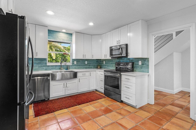 kitchen featuring a sink, tasteful backsplash, appliances with stainless steel finishes, and light countertops