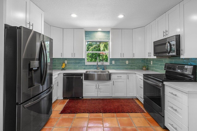 kitchen with a sink, light countertops, appliances with stainless steel finishes, white cabinetry, and backsplash