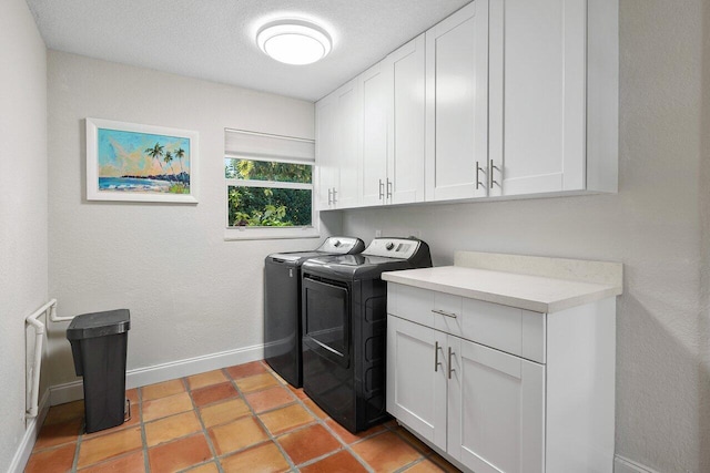 washroom with independent washer and dryer, a textured ceiling, cabinet space, tile patterned flooring, and baseboards