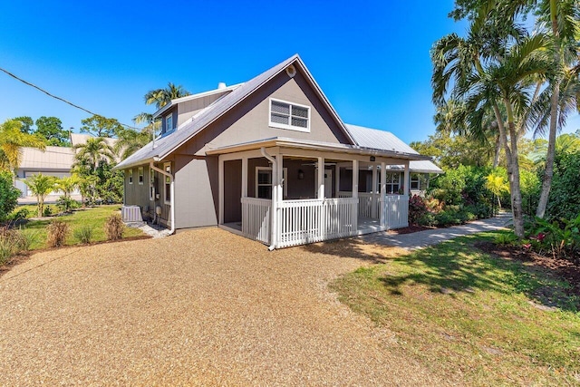 view of front of home featuring central air condition unit, covered porch, and metal roof