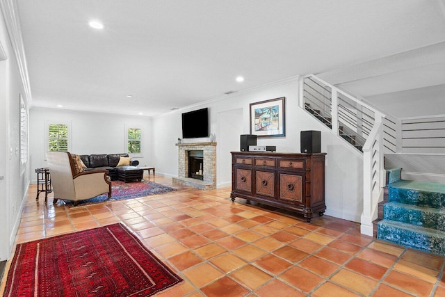 tiled living room featuring recessed lighting, a fireplace with raised hearth, crown molding, and stairs